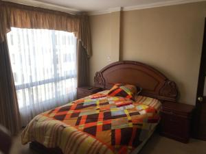 a bedroom with a bed with a colorful quilt on it at C14 de Obrajes in La Paz