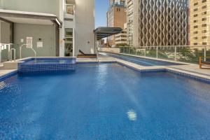 una gran piscina de agua azul en un edificio en Central 2-Bed with Pool, Sauna, Gym, BBQ & Parking en Brisbane
