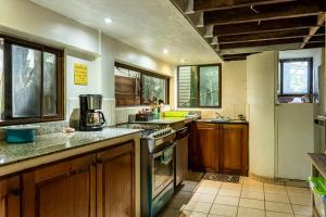 a large kitchen with wooden cabinets and counters at Garden Rooms in Bocas Town