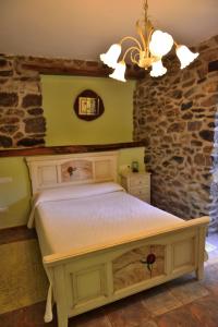 a bedroom with a bed and a stone wall at Casa rural Zulueta in Azcoitia +16 photos