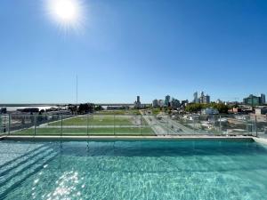 a swimming pool on the roof of a building at Alojate en METRA Puerto Norte, luminoso estudio con pileta, gym y balcon in Rosario