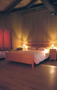 una camera con un grande letto con due lampade di B&B della Miniera a Cogne