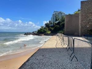 a beach with people swimming in the ocean at Flat encantador no Atlantic Towers in Salvador