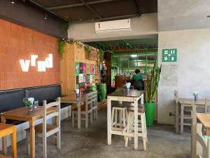 a restaurant with wooden tables and chairs and a person at Flat encantador no Atlantic Towers in Salvador