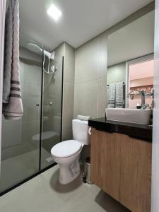 a bathroom with a toilet and a sink and a shower at Studio Aconchegante in Poços de Caldas