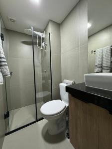 a bathroom with a toilet and a shower and a sink at Studio Aconchegante in Poços de Caldas