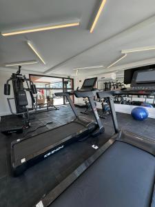 a gym with treadmills and elliptical machines at Studio Aconchegante in Poços de Caldas