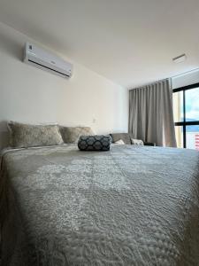 a bedroom with a large bed and a window at Studio Aconchegante in Poços de Caldas