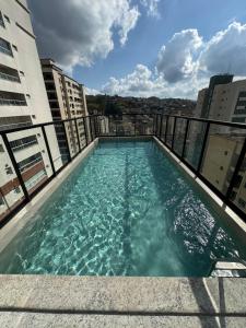 a swimming pool on the roof of a building at Studio Aconchegante in Poços de Caldas