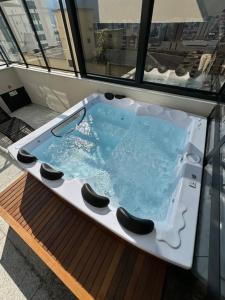 a jacuzzi tub in the middle of a balcony at Studio Aconchegante in Poços de Caldas