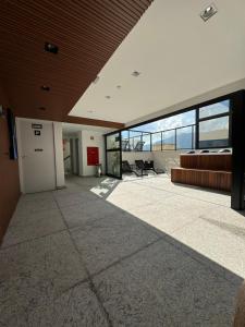 an empty lobby with a couch and chairs in a building at Studio Aconchegante in Poços de Caldas