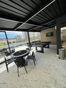 a room with a ping pong table and chairs with a view at Studio Aconchegante in Poços de Caldas