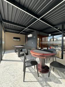 a patio with a ping pong table and chairs at Studio Aconchegante in Poços de Caldas