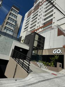 a building with a go sign next to two tall buildings at Studio Aconchegante in Poços de Caldas