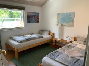 ein Schlafzimmer mit zwei Betten und einem Fenster in der Unterkunft Ferienhaus Villa Sun Rügen in Vaschvitz