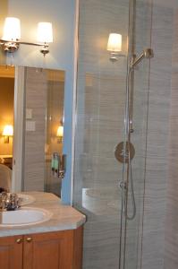 uma casa de banho com um chuveiro e um lavatório. em Hôtel Maison Blanche em New Carlisle