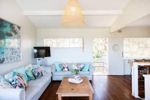 a living room with a couch and a table at The Mook on Mollymook Beach in Mollymook +12 photos