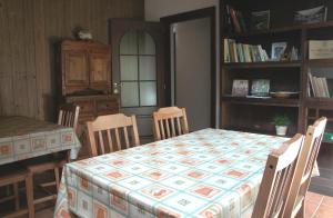 een eetkamer met een tafel en stoelen en een boekenplank bij B&B della Miniera in Cogne