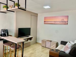 a living room with a table and a tv at Casa inteira 2 quartos super equipada in Campo Grande +7 photos