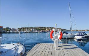 a dock with boats in the water with a life preserver at 2 Bedroom Cozy Apartment In Rönnäng in Rönnäng +6 photos