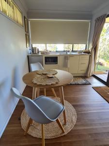 a small kitchen with a table and a chair at Waterfront in the Mountains in Wentworth Falls