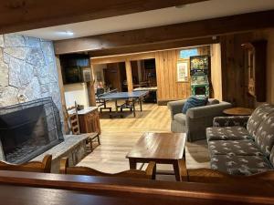 a living room with a couch and a fireplace at Bromley Farmhouse close to skiing and hikes in Peru