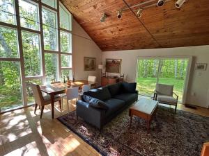 a living room with a couch and a table at Classic VT Aframe - Minutes to Mountains in Peru