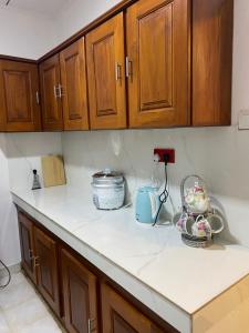 a kitchen with wooden cabinets and white counter tops at Golden Mangrove - Close to Airport and Negombo Beach in Negombo +3 photos