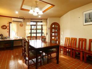a dining room with a wooden table and chairs at Kawaguchiko Inn Yesterday in Fujikawaguchiko
