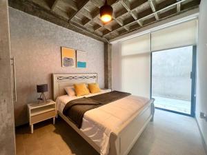 a bedroom with a bed and a large window at Tinta & hierro Suite 2 in Loja