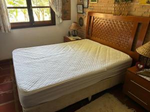a bedroom with a large white bed in a room at Casa de Campo em Ibiúna de frente para represa in Ibiúna +49 photos