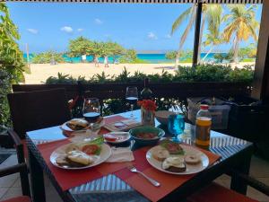 a table with plates of food and a view of the beach at Ocean Front Sapphire del Mar B-107 in St Thomas