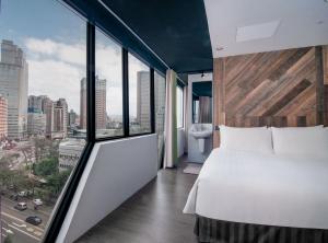 a bedroom with a large bed and a large window at Calligraphy Greenway Hotel in Taichung