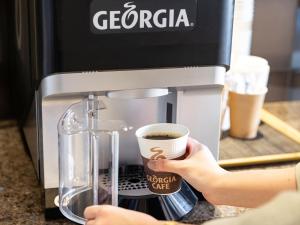 a person is making coffee in a coffee maker at Tokyu Stay Shimbashi - Ginza area in Tokyo