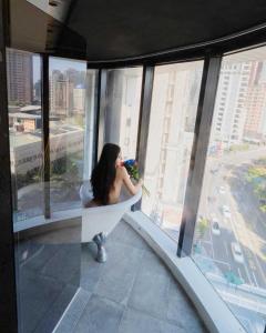 a woman sitting in a bath tub in a building at Calligraphy Greenway Hotel in Taichung