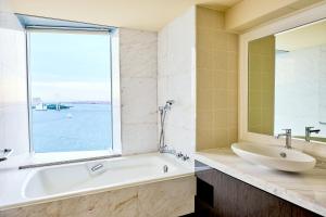 a bathroom with a tub and a sink and a window at InterContinental Tokyo Bay by IHG in Tokyo