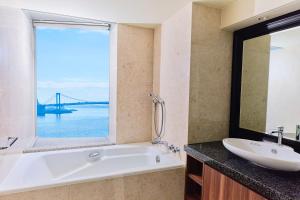 a bathroom with a tub and a sink and a window at InterContinental Tokyo Bay by IHG in Tokyo