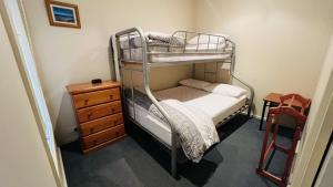 - une petite chambre avec des lits superposés et une commode dans l'établissement Sunrise Ocean Views Retreat Cowes Phillip Island, à Cowes