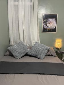 a bed with two pillows in front of a window at Nordic Style Homestay Davao in Davao City