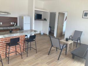a kitchen with chairs and a counter in a room at Condominio cerca salida norte Lomas de Cocoyoc in Texcalpan