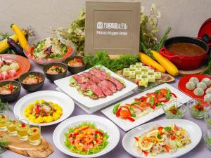 a table topped with plates of food and vegetables at Manza Kogen Hotel in Tsumagoi