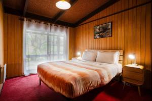 a bedroom with a large bed and a window at Old Mill Park in Bright