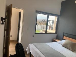 a bedroom with a bed and a large window at Condominio cerca salida norte Lomas de Cocoyoc in Texcalpan +39 photos
