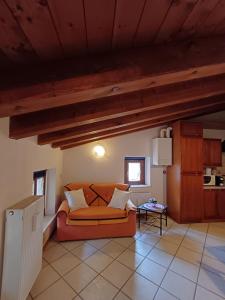 a living room with an orange couch and a table at Splendida Mansarda, aria condizionata "ALLE MURA DEL CASTELLO 2 Stefano e Paola Marchesini" in Gorizia