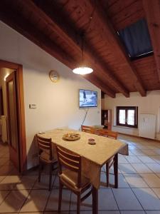 a dining room with a table and chairs and a tv at Splendida Mansarda, aria condizionata "ALLE MURA DEL CASTELLO 2 Stefano e Paola Marchesini" in Gorizia