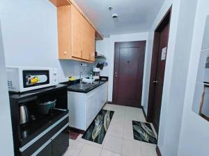 een kleine keuken met een spoelbak en een magnetron bij Baguio Condotel - City Center in Baguio