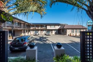 a car parked in a parking lot in front of a motel at Pigeon House Motor Inn in Ulladulla