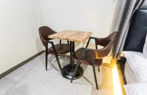 a table and two chairs in a room at The Sharp Hotel in Changwon