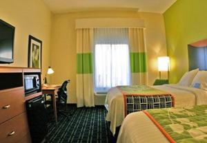 a hotel room with two beds and a television at Fairfield Inn Suites Brunswick in Brunswick