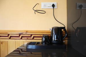 two coffee pots sitting on a table next to a lightswitch at Hotel Spiti Heritage in Kaza